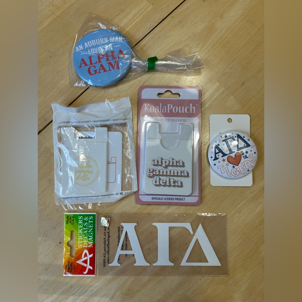 Lot of two Alpha Gamma Delta phone wallets, two game day pins, & one large decal